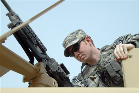 Senior Airman Aaron Skelton mans an M240 machine gun in the turret of a Joint EOD Rapid Response Vehicle in Iraq